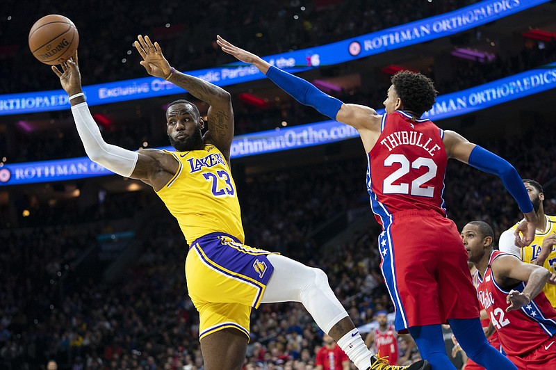 Los Angeles Lakers star LeBron James passes the ball as the Philadelphia 76ers' Matisse Thybulle, right, defends during the first half of Saturday night's game in Philadelphia. / AP photo by Chris Szagola