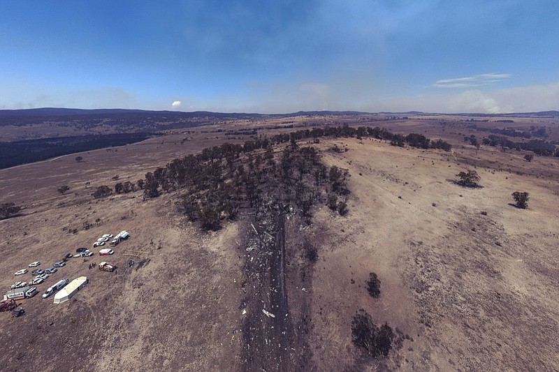 This Friday, Jan. 24, 2020, aerial photo provided by the New South Wales Police, shows wreckage, center, is strewn at the crash site of a firefighting air tanker near Numeralla, south west of Sydney. Three crew from the U.S. were killed when their C-130 Hercules tanker crashed while fighting wildfires in Australia, their employer, Canada-based Coulson Aviation, said in a statement. (NSW Police via AP)

