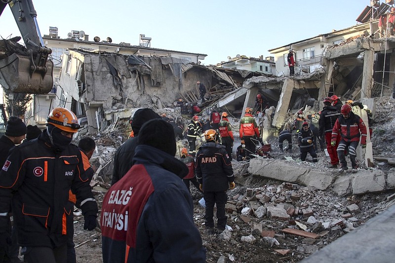 Rescue workers try to save people trapped under debris following a strong earthquake that destroyed several buildings on Friday, in Elazig, eastern Turkey, Sunday, Jan. 26, 2020. Rescue workers were continuing to search for people buried under the rubble of apartment blocks in Elazig and neighboring Malatya. Mosques, schools, sports halls and student dormitories were opened for hundreds who left their homes after the quake. (Ismail Coskun/IHA via AP)