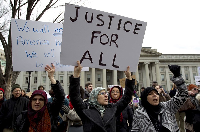 FILE - In this Jan. 29, 2017 file photo, demonstrators carrying signs chant as they protest outside of the White House in Washington during a demonstration to denounce President Donald Trump's executive order banning travel to the U.S. by citizens of Iraq, Syria, Iran, Sudan, Libya, Somalia and Yemen. Trump's travel ban on travelers from predominantly Muslim countries is headed back to a federal appeals court, three years after it was first imposed. On Tuesday, Jan. 27, 2020, the 4th U.S. Circuit Court of Appeals in Richmond is scheduled to hear arguments in three lawsuits filed by U.S. citizens and permanent residents whose relatives have been unable to enter the U.S. because of the ban. (AP Photo/Jose Luis Magana, File)