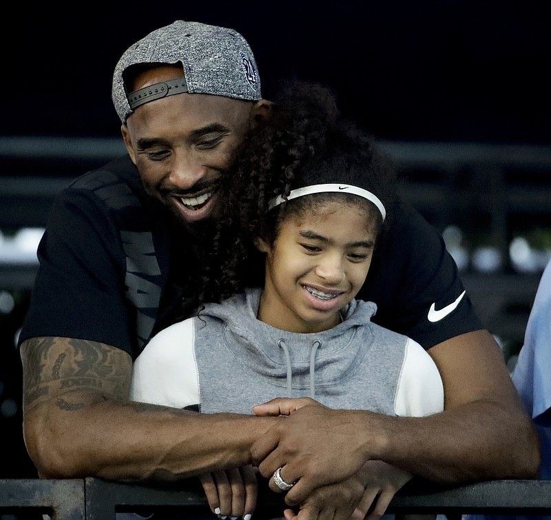 Former Los Angeles Lakers star Kobe Bryant and his daughter Gianna watch during the U.S. national championships swimming meet on July 26, 2018, in Irvine, Calif. A helicopter crash in the Los Angeles area that killed all nine people on board on Sunday, Jan. 26, 2020, included Bryant, 41, and Gianna, 13. / AP photo by Chris Carlson