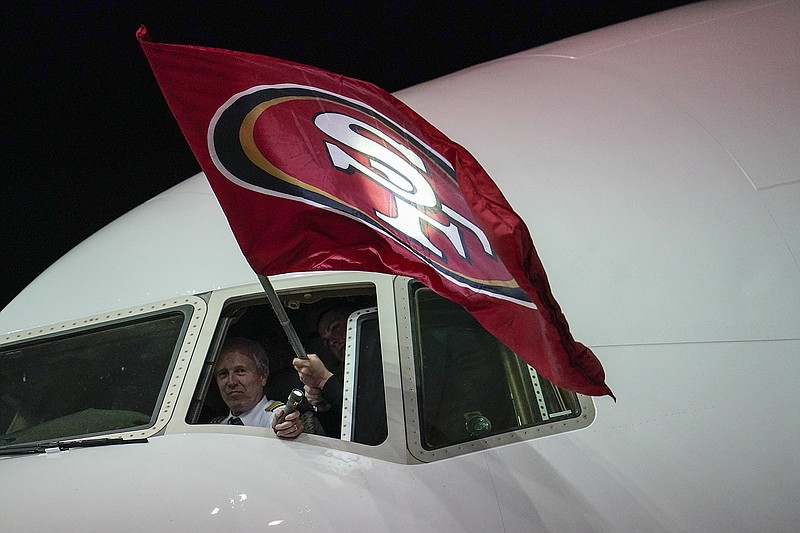 A pilot holds a San Francisco 49ers flag as the NFC champions arrive at Miami International Airport on Sunday, a week before they take on the Kansas City Chiefs in Super Bowl LIV at Hard Rock Stadium in Miami Gardens, Fla. / AP photo by David J. Phillip