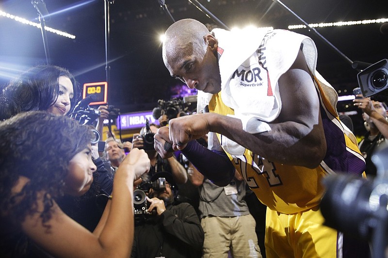 FILE - In this April 13, 2016 file photo Los Angeles Lakers' Kobe Bryant, right, fist-bumps his daughter Gianna after the last NBA basketball game of his career, against the Utah Jazz in Los Angeles. Bryant, the 18-time NBA All-Star who won five championships and became one of the greatest basketball players of his generation during a 20-year career with the Los Angeles Lakers, died in a helicopter crash Sunday, Jan. 26, 2020. Gianna also died in the crash. (AP Photo/Jae C. Hong, file)