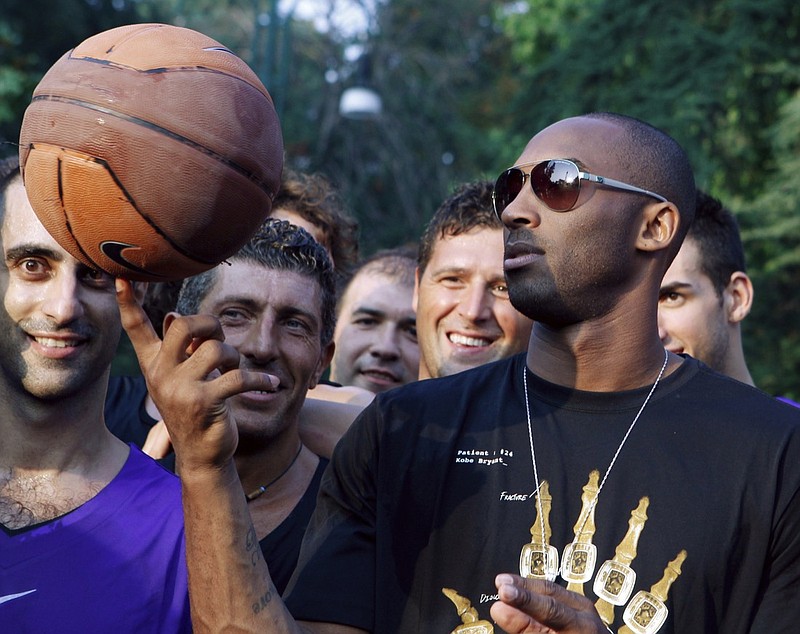 FILE - In this Sept. 28, 2011, file photo, U.S. basketball star Kobe Bryant plays with a ball during a sponsor's appearance in Milan, Italy. In Europe where Bryant grew up, the retired NBA star is being remembered for his "Italian qualities." Italian basketball federation president Giovanni Petrucci tells The Associated Press that Bryant is "particularly important to us because he knew Italy so well, having lived in several cities here. He had a lot of Italian qualities." (AP Photo/Luca Bruno, File)