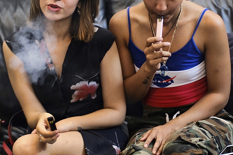 In this June 8, 2019, file photo, two women smoke cannabis vape pens at a party in Los Angeles. California officials announced Monday, Jan. 27, 2020, that marijuana vape cartridges seized in illegal shops in Los Angeles contained potentially dangerous additives, including a thickening agent blamed for a national outbreak of deadly lung illnesses tied to vaping. (AP Photo/Richard Vogel)