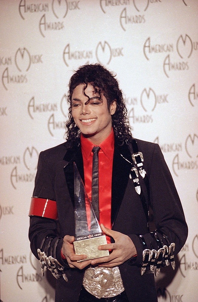 Michael Jackson holds an American Music Award for lifetime achievement in Los Angeles, Monday night, Jan. 30, 1989. (AP Photo/Lennox McLendon)