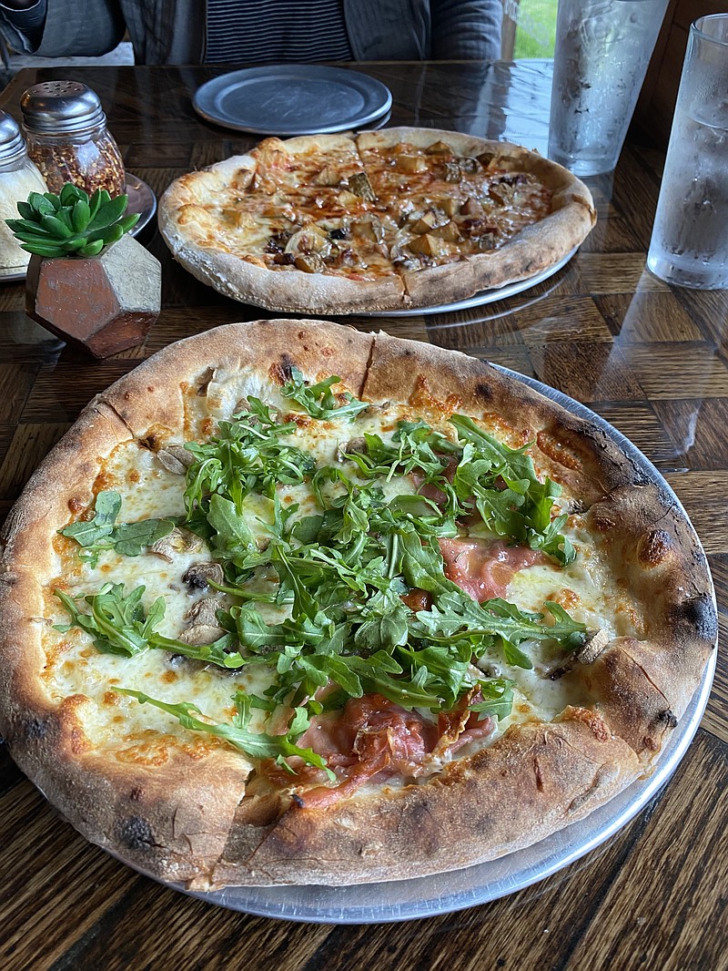 Photo by Barry Courter / During our visit to Pizzeria Cortile, we ordered the Fancy Pants, foreground, with olive oil, cheese blend, Tennshootoe (on half only), arugula, lemon juice and salt. We also got the Mr. Potato Head, which has red sauce, cheese blend, house-made bacon (half only), embered onions, fried potatoes, rosemary and hot honey.