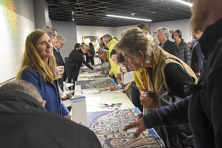 Rebecca Lassman, left, of HR&A Advisors, left, directs people offering ideas for the waterfront district as more than 200 people attended a Riverfront visioning public meeting on Wednesday, Jan. 29, 2020, to look over a maps of the riverfront at the Tennessee Aquarium. / Staff photo by Tim Barber