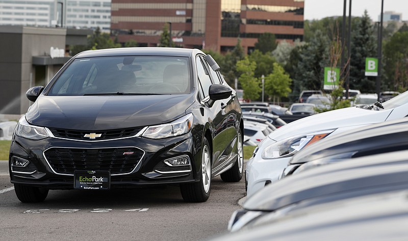 FILE - In this June 26, 2018, file photograph, a used 2017 Chevrolet Cruze sits in a row of other used, late-model sedans at a dealership in Centennial, Colo. Consumers bought an estimated 40.4 million used vehicles last year, likely passing the old record of 40.2 million set in 2018, according to figures from the Edmunds.com auto pricing site. (AP Photo/David Zalubowski, File)