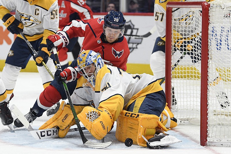 Washington Capitals center Lars Eller, in red, and Nashville Predators goaltender Juuse Saros battle for the puck during the second period of Wednesday night's game in Washington. / AP photo by Nick Wass