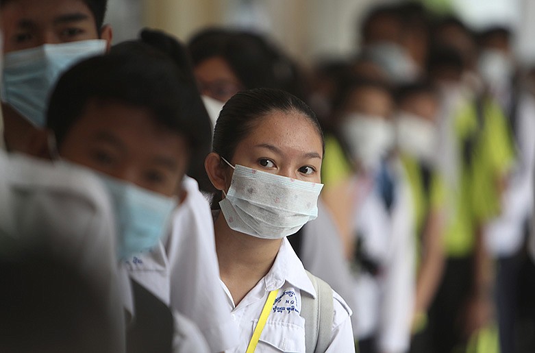 Students line up to sanitize their hands to avoid contact with coronavirus before their morning class at a high school in Phnom Penh, Cambodia, Tuesday, Jan. 28, 2020. China on Tuesday reported 25 more deaths from the new viral disease, as the U.S. government prepared to fly Americans out of the city at the center of the outbreak. (AP Photo/Heng Sinith)