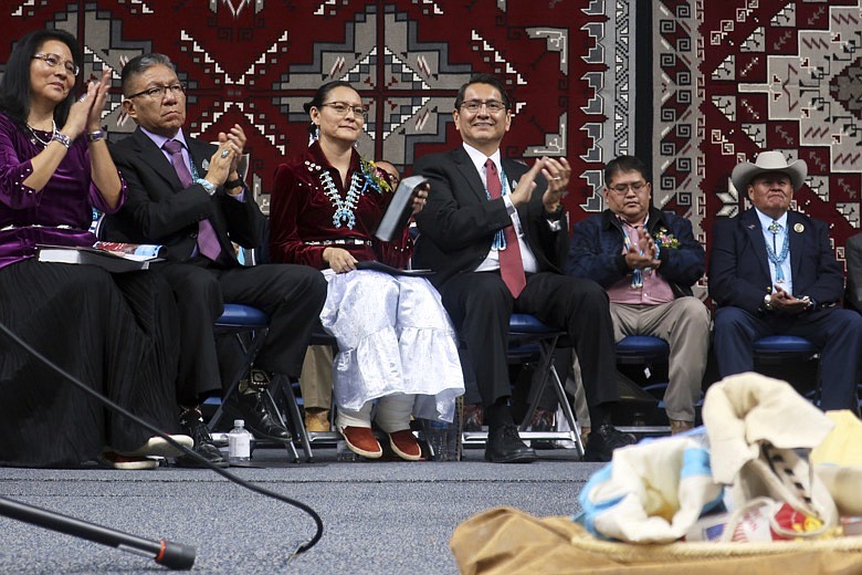 In this Jan. 15, 2019, file photo, from left, Dottie Lizer, Navajo Nation Vice President Myron Lizer, first lady Phefelia Herbert Nez and Navajo President Jonathan Nez sit onstage during the tribal inauguration in Fort Defiance, Ariz. As the coal industry nears its end on the Navajo Nation, the tribe is looking to Arizona utilities that shared in the power generated on the reservation to help make up for the financial losses and environmental impacts. "Coal communities should be provided financial resources for their historical contributions to economic development and to help transition into new, low-carbon work," Navajo President Jonathan Nez and Vice President Myron Lizer wrote to the Arizona Corporation Commission. (AP Photo/Felicia Fonseca, File)