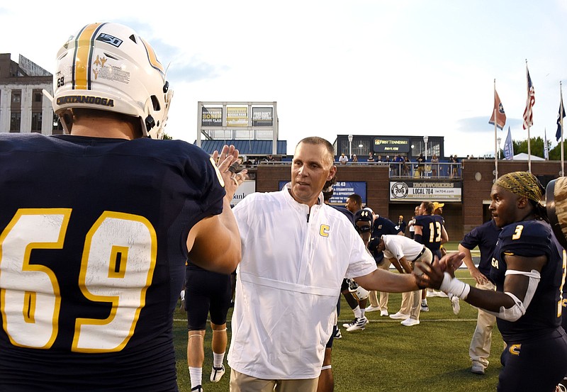 UTC football coach Rusty Wright congratulates Cole Strange (69) and Drayton Arnold after the Mocs' 60-36 homecoming victory over Western Carolina to open SoCon play on Sept. 28, 2019. / Staff photo by Robin Rudd