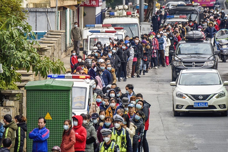 People line up to buy face masks from a medical supply company in Nanning in southern China's Guangxi Zhuang Autonomous Region, Wednesday, Jan. 29, 2020. Countries began evacuating their citizens Wednesday from the Chinese city hardest-hit by a new virus that has now infected more people in China than were sickened in the country by SARS. (Chinatopix via AP)