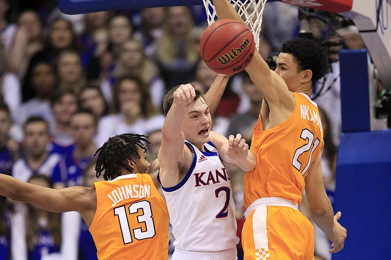 Tennessee guard Jalen Johnson (13) and forward Olivier Nkamhoua sandwich Kansas guard Christian Braun during a Big 12/SEC Challenge game last Saturday in Lawrence, Kan. Tennessee lost 74-68 and lost again at home Tuesday, 63-58 to Texas A&M. / AP photo by Orlin Wagner