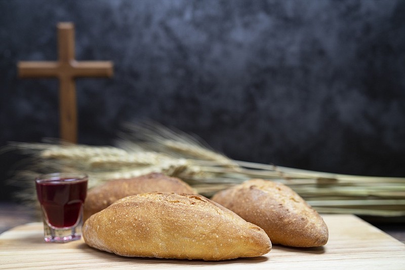 Selective focus of bread and grape beverage with wooden cross for background. Inspiration faith tile church tile communion tile. / Getty Images
