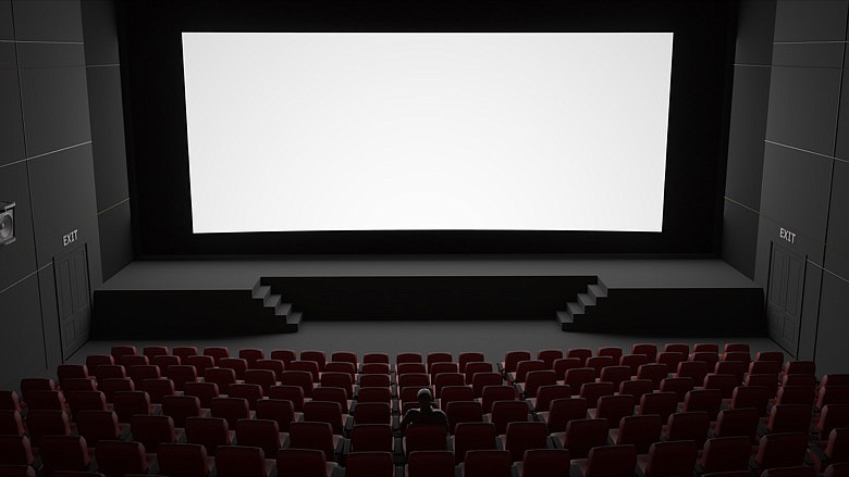 Man sitting in empty cinema. / Getty Images/iStockphoto/omendrive