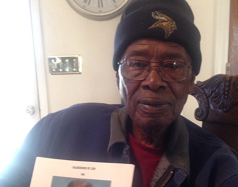 Sitting in his Chattanooga home, Marvin Lee holds a photo of his deceased brother, Earl Alonzo Lee, a member of the historic Black 14. / Photo by David Cook