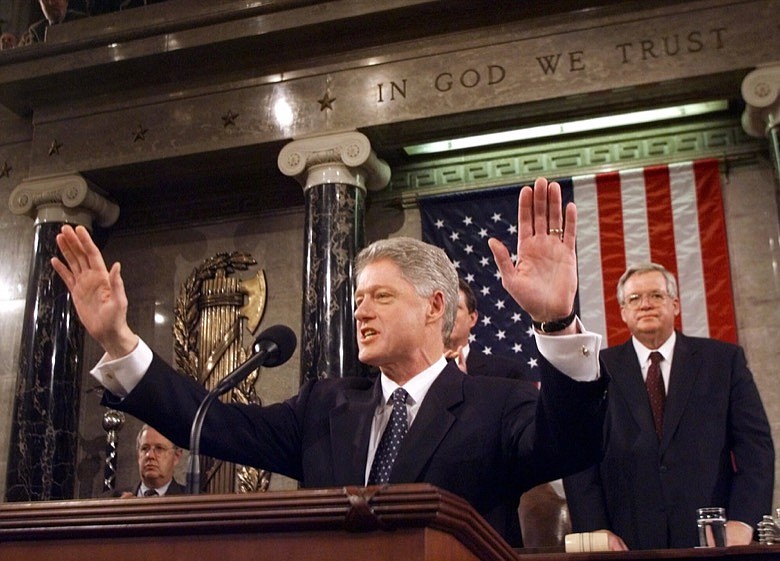 In this Jan. 19, 1999 file photo, President Clinton acknowledges the crowd prior to giving his State of the Union address on Capitol Hill . House Speaker Dennis Hastert of Illinois is at right. Two decades ago, President Bill Clinton delivered his State of the Union address before a nation transfixed by his impeachment. He didn't use the I-word once. President Donald Trump is far from the first president to deliver a State of the Union address in a time of turmoil. (AP Photo/Win McNamee, Pool, File)