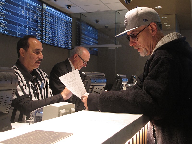 A gambler places bets on Super Bowl LIV at Bally's casino on Jan. 29 in Atlantic City, N.J. Gambling industry officials expect Sunday's NFL title matchup between the Kansas City Chiefs and the San Francisco 49ers in Miami to be among the most heavily wagered-on championship games ever. / AP photo by Wayne Parry
