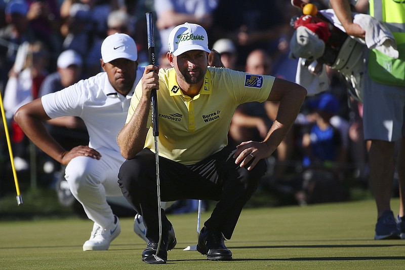 Webb Simpson, front, and Tony Finau line up their putts on the 18th green during the final round of the PGA Tour's Waste Management Phoenix Open on Sunday in Scottsdale, Ariz. / AP photo by Ross D. Franklin