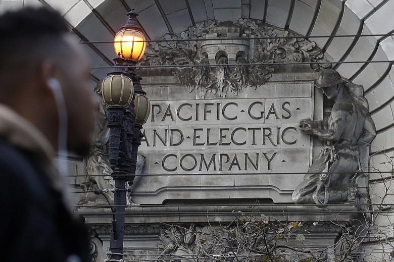 In this Dec. 16, 2019, file photo, a sign to a Pacific Gas & Electric building is shown in San Francisco. Pacific Gas & Electric is assuring a federal judge Wednesday, Jan. 29, 2020, it will meet a June 30 deadline for getting out of bankruptcy, as California Gov. Gavin Newsom signaled his intent to follow through on his threat to attempt a government takeover of the nation's largest utility. (AP Photo/Jeff Chiu, File)