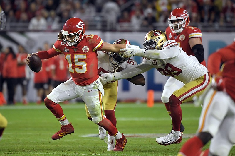 AP photo by Mark J. Terrill / Kansas City Chiefs quarterback Patrick Mahomes tries to scramble away from the San Francisco 49ers' Dee Ford, center, and DeForest Buckner, right, during the second half of Super Bowl LIV on Feb. 2 iin Miami Gardens, Fla.