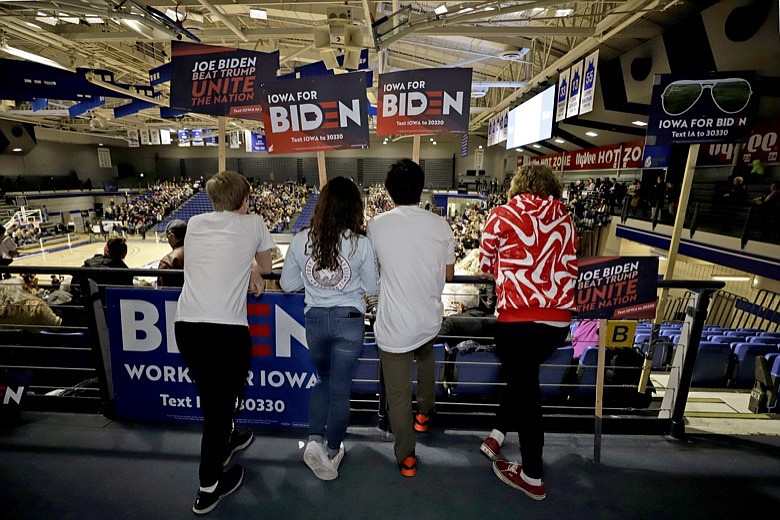 Younger caucus goers hold signs for Democratic presidential candidate former Vice President Joe Biden at the Knapp Center on the Drake University campus in Des Moines, Iowa, Monday, Feb. 3, 2020. (AP Photo/Gene J. Puskar)