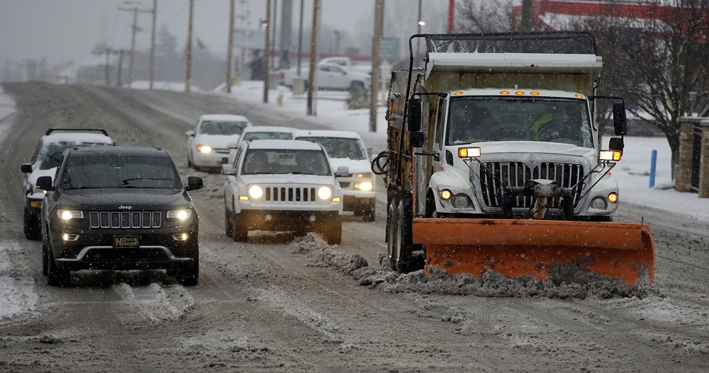 A truck plows snow, ice and slush from 11th Street at Harvard Ave. in Tulsa, Okla., Wednesday, Feb. 5, 2020. (Mike Simons/Tulsa World via AP)