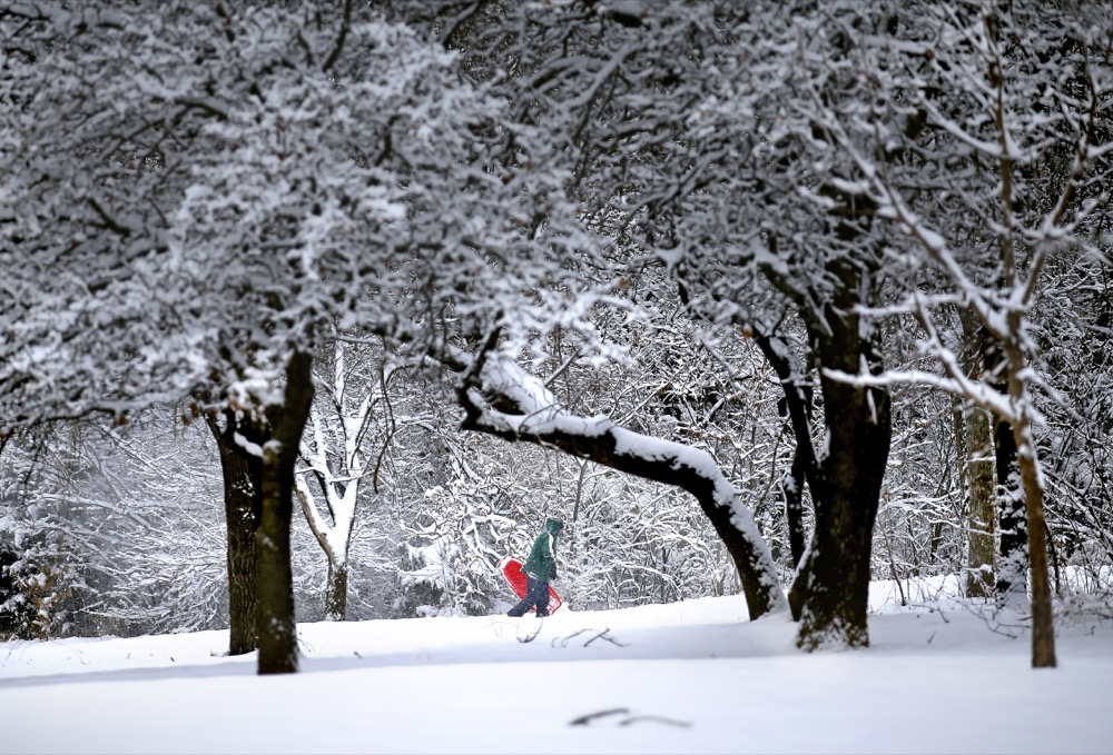 Denise Hendricks walks up a snow covered hill while sledding at Hafer Park following a winter storm in Edmond, Okla., Wednesday, Feb. 5, 2020. (Sarah Phipps/The Oklahoman via AP)