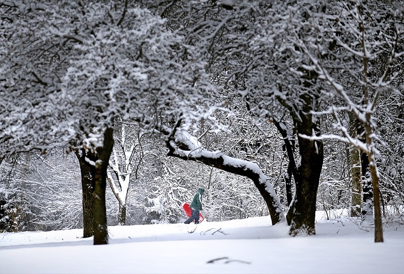 Denise Hendricks walks up a snow covered hill while sledding at Hafer Park following a winter storm in Edmond, Okla., Wednesday, Feb. 5, 2020. (Sarah Phipps/The Oklahoman via AP)

