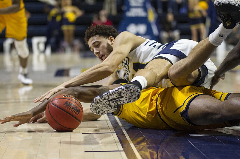 UTC's Rod Johnson lands on an East Tennessee State player as he fights for a loose basketball during Wednesday night's SoCon game at McKenzie Arena. / Staff photo by Troy Stolt