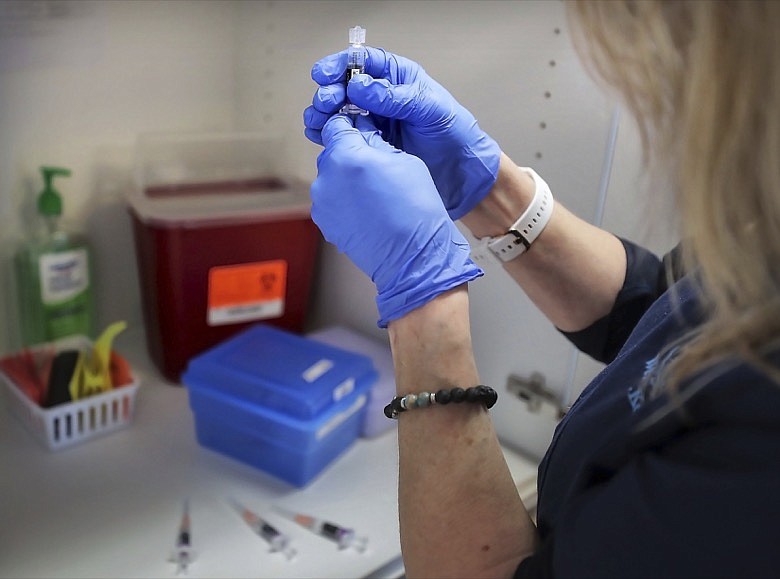 CMA Wendy Kerley prepares the flu vaccine before inoculating the Getman family Friday, Jan. 3, 2019, at the Cordova Shot Nurse clinic on Germantown Rd. in Memphis, Tenn. (Jim Weber/Daily Memphian via AP)