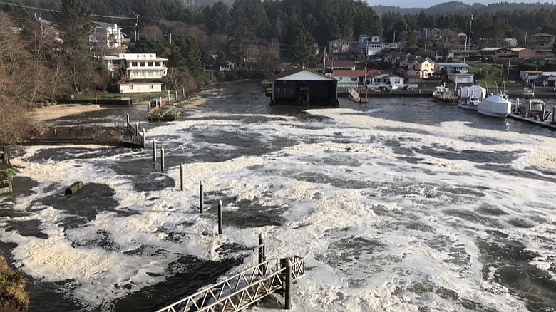 In this Jan. 11, 2020 photo an extreme high tide rolls in and floods parts of the harbor in Depoe Bay, Ore. during a so-called "king tide" that coincided with a big winter storm. Amateur scientists are whipping out their smartphones to document the effects of extreme high tides on shore lines from the United States to New Zealand, and by doing so are helping better predict what rising sea levels due to climate change will mean for coastal communities around the world. (AP Photo/Gillian Flaccus)