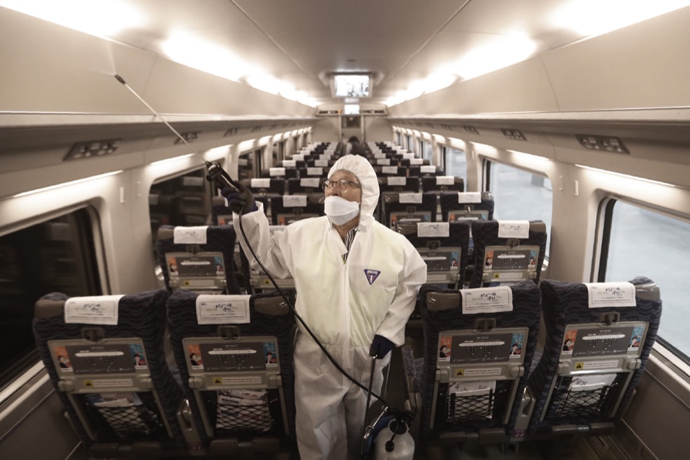 FILE - In this Jan. 24, 2020, file photo, an employee sprays disinfectant on a train as a precaution against a new coronavirus at Suseo Station in Seoul, South Korea. Halting the spread of a new virus that has killed hundreds in China is difficult in part because important details about the illness and how it spreads are still unknown. (AP Photo/Ahn Young-joon, File)
