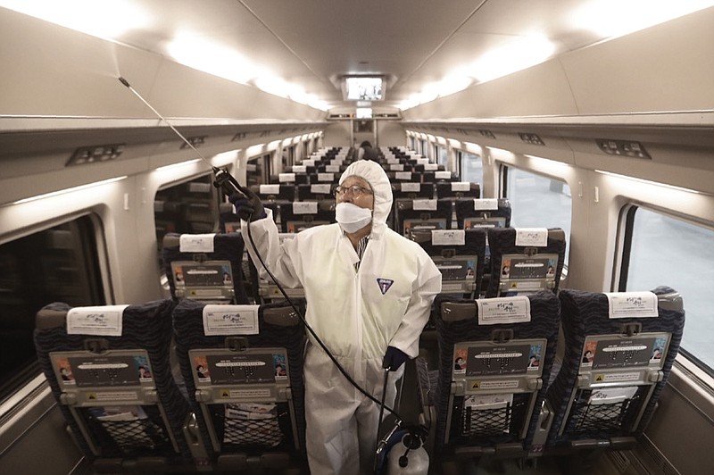 FILE - In this Jan. 24, 2020, file photo, an employee sprays disinfectant on a train as a precaution against a new coronavirus at Suseo Station in Seoul, South Korea. Halting the spread of a new virus that has killed hundreds in China is difficult in part because important details about the illness and how it spreads are still unknown. (AP Photo/Ahn Young-joon, File)

