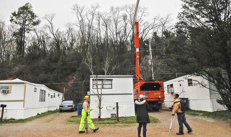 Staff photo by Troy Stolt / City workers try to clear out limbs from a broken tree in the Signal Mountain Mobile Courts to inspect the slope behind the homes on Thursday, Feb. 6, 2020 in Chattanooga, Tenn.
