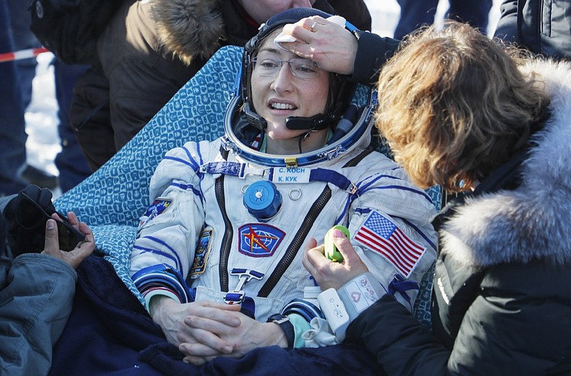 Specialists help U.S. astronaut Christina Koch shortly after the landing of the Russian Soyuz MS-13 space capsule about 150 km ( 80 miles) south-east of the Kazakh town of Dzhezkazgan,  Kazakhstan, Thursday, Feb. 6, 2020. A Soyuz space capsule with U.S. astronaut Christina Koch, Italian astronaut Luca Parmitano and Russian cosmonaut Alexander Skvortsov, returning from a mission to the International Space Station landed safely on Thursday on the steppes of Kazakhstan. Koch wrapped up a 328-day mission on her first flight into space, providing researchers the opportunity to observe effects of long-duration spaceflight on a woman as the agency plans to return to the Moon under the Artemis program. (Sergei Ilnitsky/Pool Photo via AP)