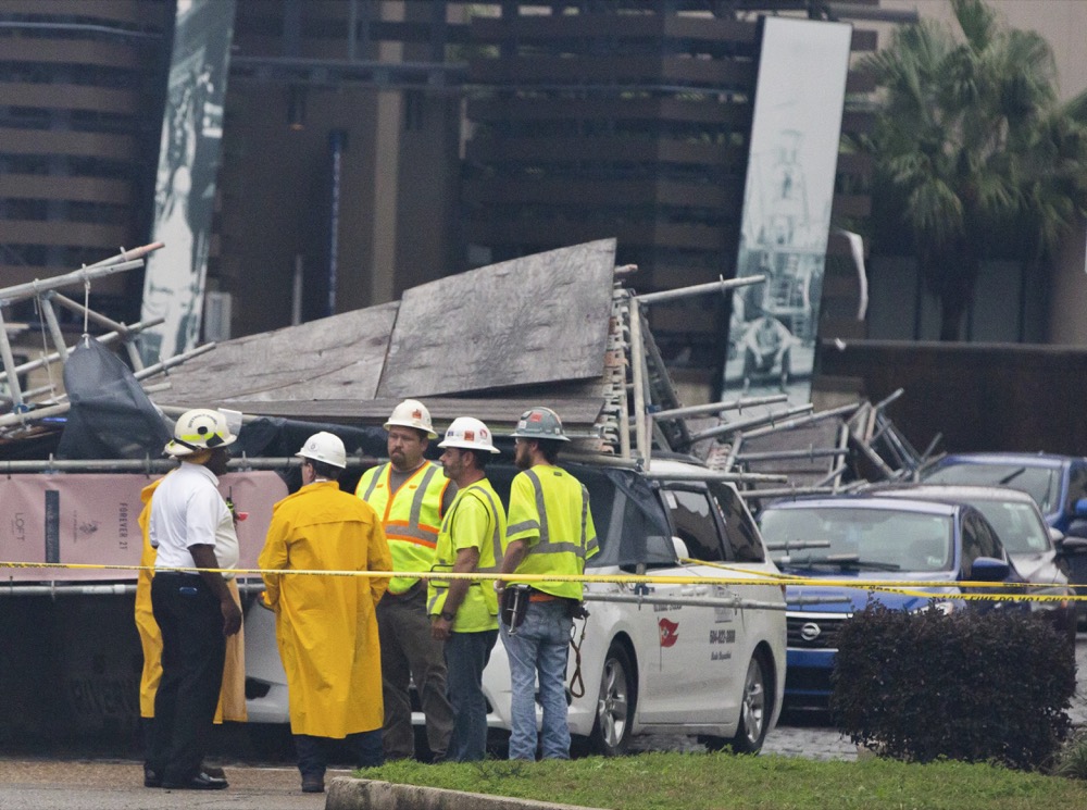 A portion of scaffolding is on top of cars at the former World Trade Center construction site after severe weather in New Orleans, La., Wednesday, Feb. 5, 2020. A section of scaffolding at the Four Seasons Hotel construction site in New Orleans collapsed onto at least a dozen cars Wednesday, leaving at least one person injured, as thunderstorms and high winds moved through the area. (Sophia Germer/The Advocate via AP)