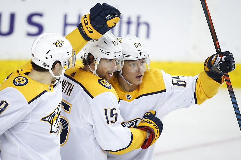 The Canadian Press photo by Fred Chartrand via AP / Mikael Granlund, right, celebrates his goal with Nashville teammates Craig Smith, center, and Filip Forsberg during the second period of the Predators' 3-2 road win against the Calgary Flames on Thursday night.