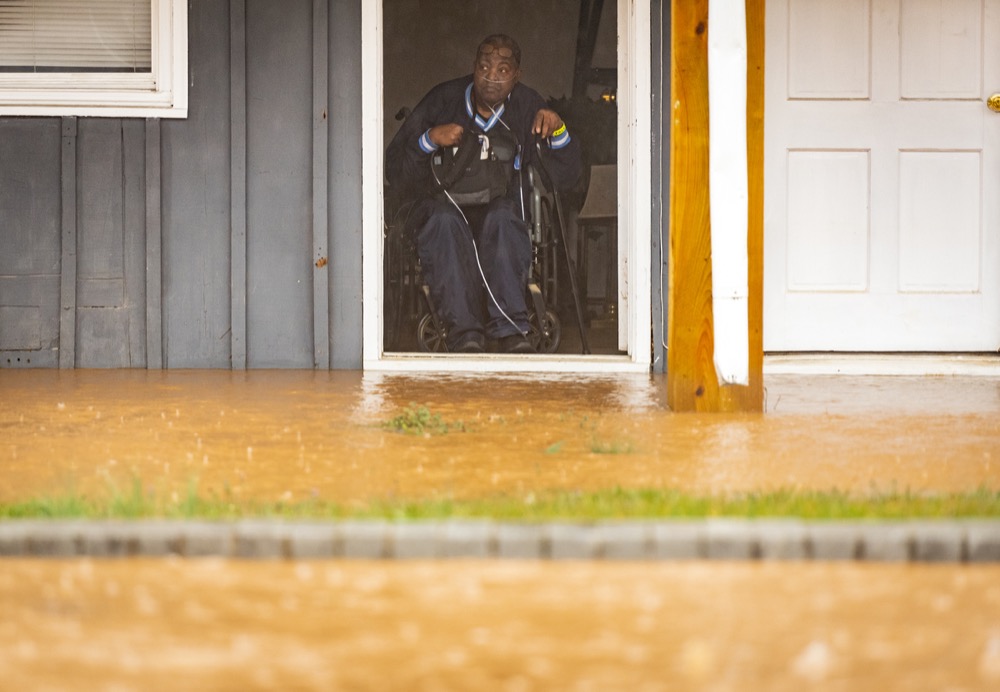 Donald Harris looks out from his apartment at Liberty Landing Apartments as flood waters rise around his home on Thursday, Feb. 6, 2020 in Winston-Salem, N.C. (Andrew Dye/The Winston-Salem Journal via AP)