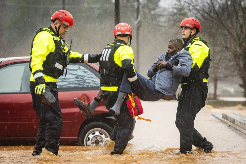 Winston-Salem Fire Department firefighters with the Rescue Task Force rescue Donald Harold from his home at Liberty Landing Apartments as flood waters rise around the building on Thursday, Feb. 6, 2020 in Winston-Salem, N.C. (Andrew Dye/The Winston-Salem Journal via AP)