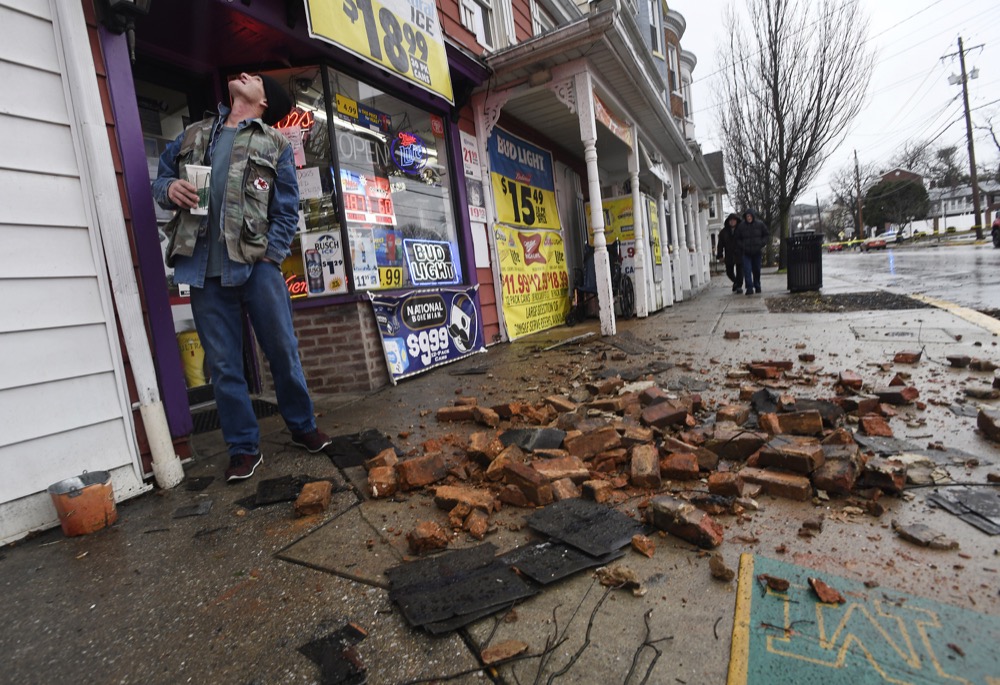 Terry Humple looks at roof damage above Carriage House Liquors on West Main Street after a powerful storm swept through Westminster, Md., Friday morning, Feb. 7, 2020. (Dylan Slagle/The Baltimore Sun via AP)