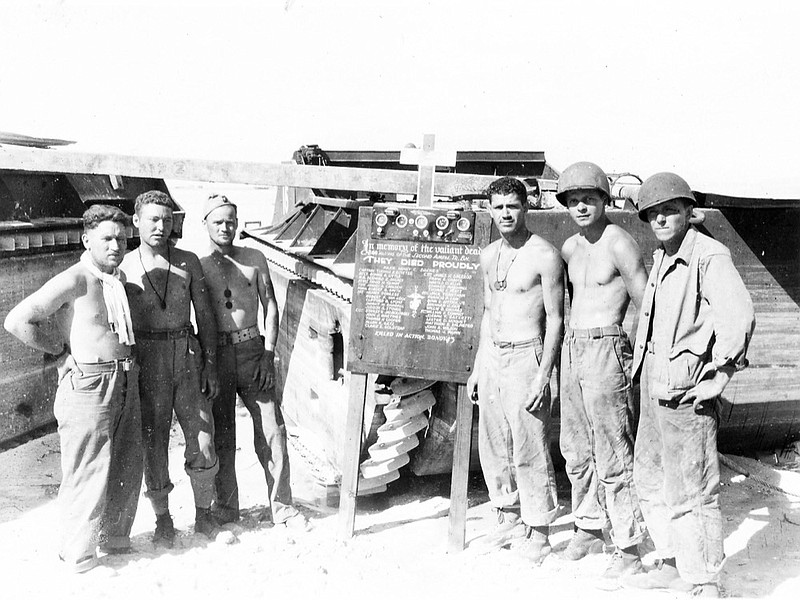 Survivors of a military unit gather around just after the battle of Tarawa during World War II. The vehicles in the back are LVTs (Landing Vehicle, Tracked also commonly called "Alligators") like the one U.S. Marine Corps Cpl. Thomas H. Cooper manned. / Photo provided by the National Archives via Geoffrey Roecker with MissingMarines