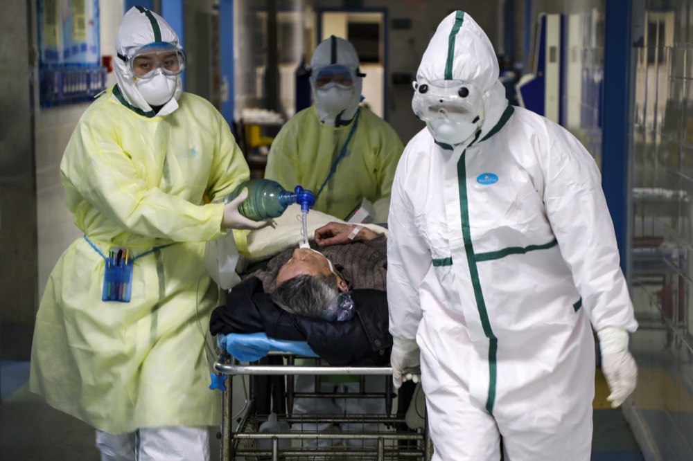 In this Thursday, Feb. 6, 2020, photo, medical workers transfer a patient in the isolation ward for 2019-nCoV patients at a hospital in Wuhan in central China's Hubei province. The number of confirmed cases of the new virus has risen again in China while fatalities increased to 722 on Saturday, Feb. 8, as the ruling Communist Party faced anger and recriminations from the public over the death of a doctor who was threatened by police after trying to sound the alarm about the disease over a month ago. (Chinatopix via AP)