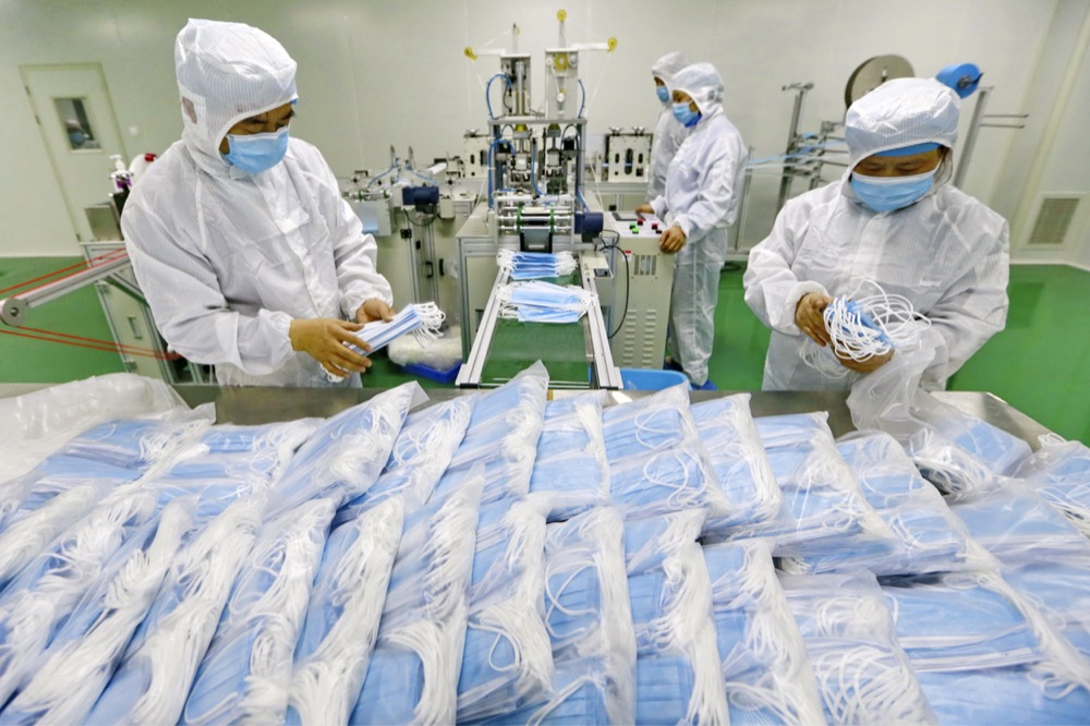 In this Friday, Feb. 7, 2020, photo, workers pack surgical masks at a factory in Suining city in southwest China's Sichuan province. The number of confirmed cases of the new virus has risen again in China while fatalities increased to 722 on Saturday, as the ruling Communist Party faced anger and recriminations from the public over the death of a doctor who was threatened by police after trying to sound the alarm about the disease over a month ago. (Chinatopix via AP)