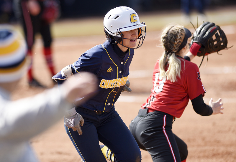 Staff Photo by Robin Rudd / UTC's Emily Coltharp (9) beats the throw to first for a single. Taking the throw is Peay's Emily Harkleroad (13). In the foreground UTC associate head coach Scottie Kilgore looks on. The University of Tennessee at Chattanooga Mocs defeated the Austin Peay Governors in NCAA softball 9 to 1 in the first game at Jim Frost Stadium on February 9, 2020.
