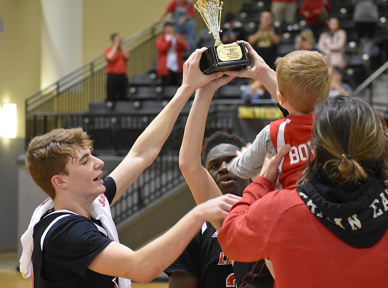 LFO freshman guard Brent Bowman, left, and senior Jacob King, center, celebrate their Region 6-AAA championship after beating North Murray on Monday night. / Staff photo by Patrick MacCoon