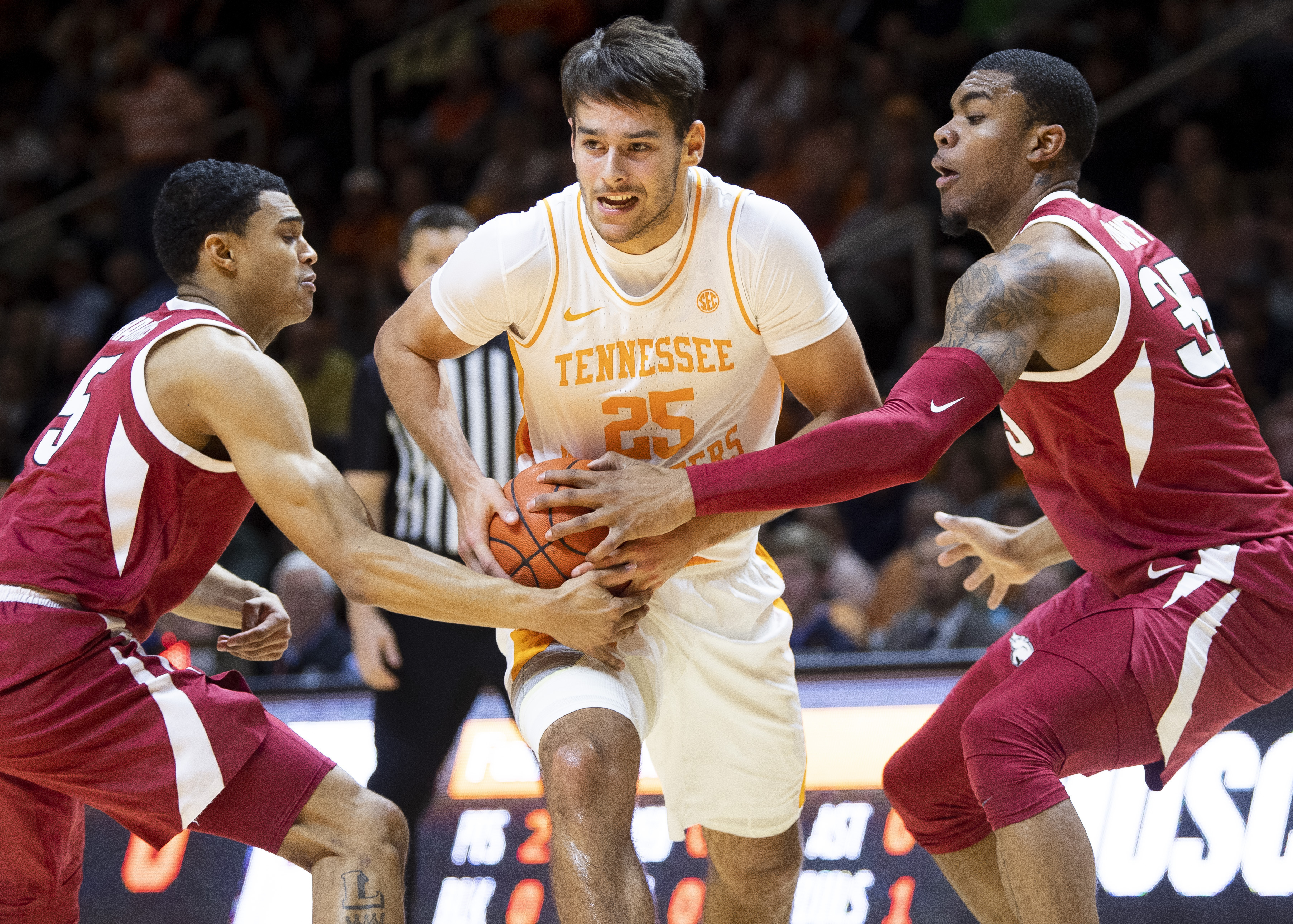 Tennessee guard Santiago Vescovi (25) moves through Arkansas guard Jalen Harris (5) and Arkansas forward Reggie Chaney (35) during an NCAA college basketball game, Tuesday, Feb. 11, 2020 in Knoxville, Tenn. (Brianna Paciorka/Knoxville News Sentinel via AP)