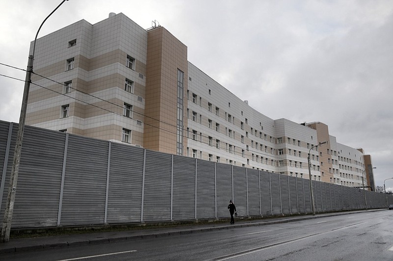 A man walks past a fence in front of the Botkin hospital in St. Petersburg, Russia, Wednesday, Feb. 12, 2020. A patient has fled the hospital where she was quarantined after coming down with a sore throat after returning to St. Petersburg from Hainan in China. (AP Photo/Dmitri Lovetsky)


